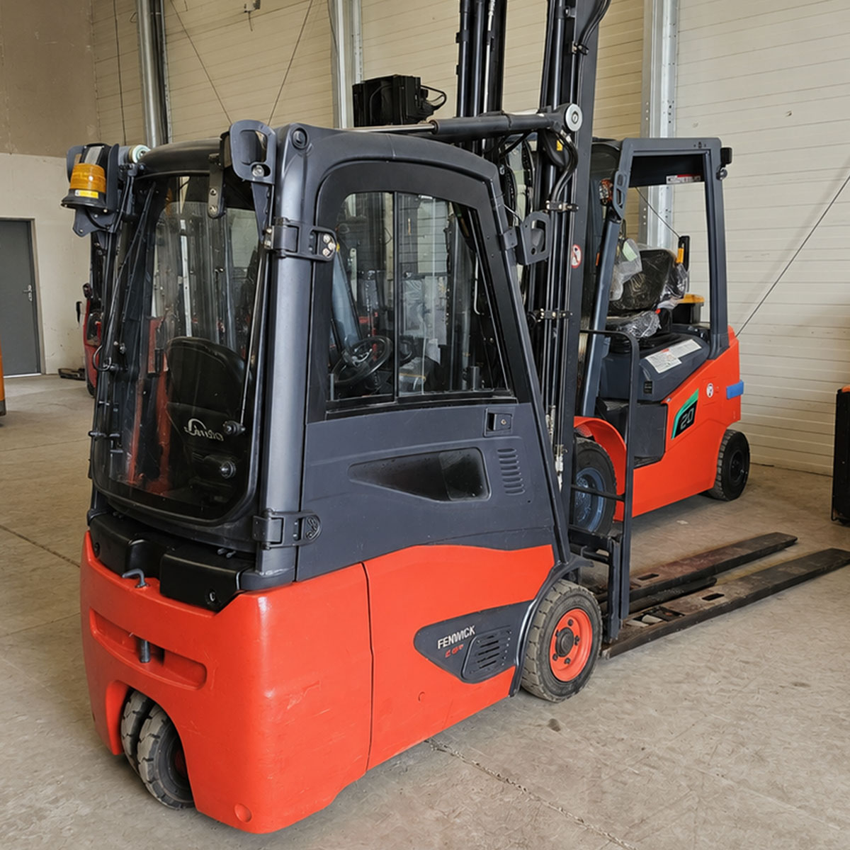 Chariot élévateur électrique FENWICK E16C01 d'occasion reconditionné avec cabine, mât triplex 6470 mm, batterie 2021 et chargeur.